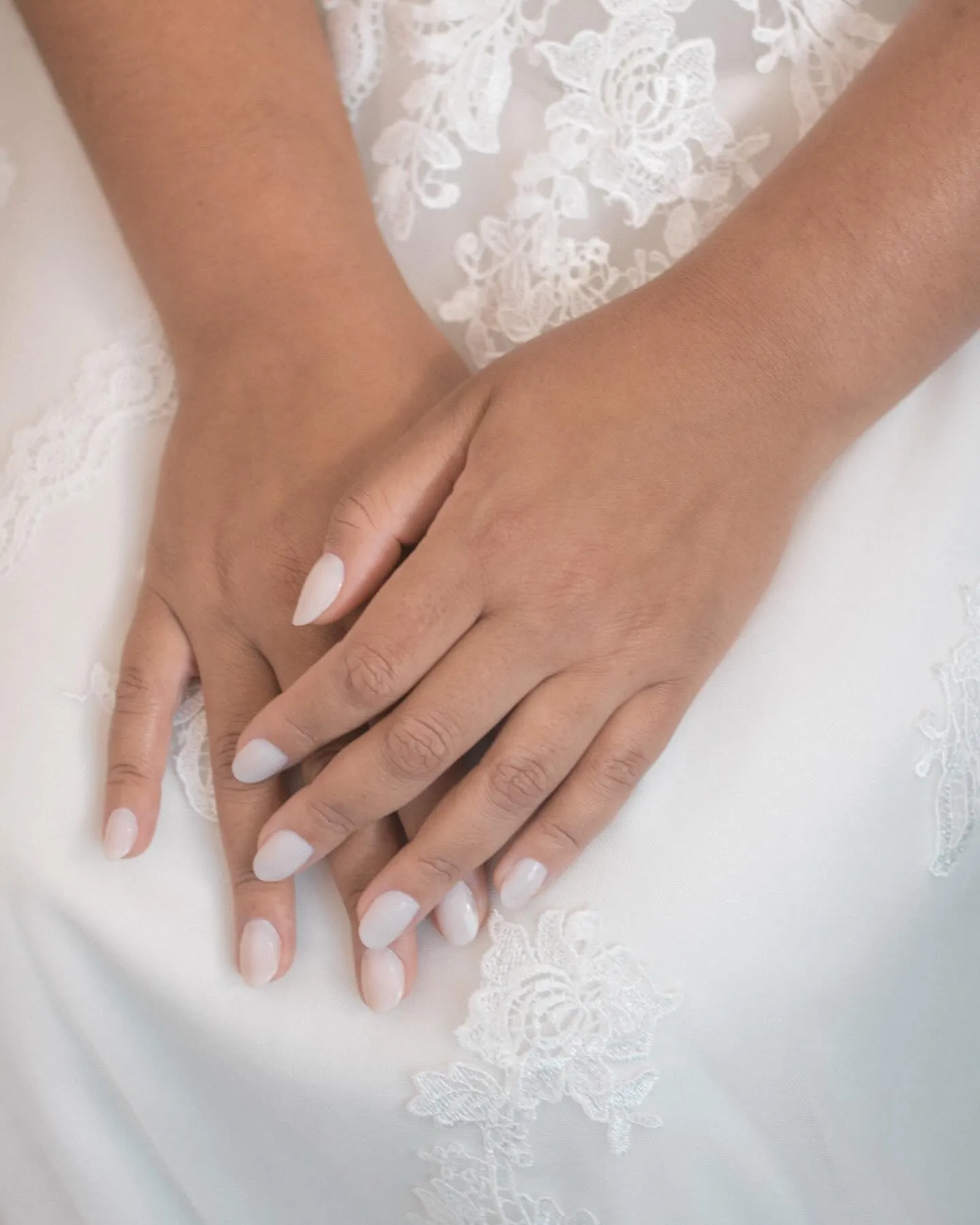 Mãos da noiva sobre o vestido de renda