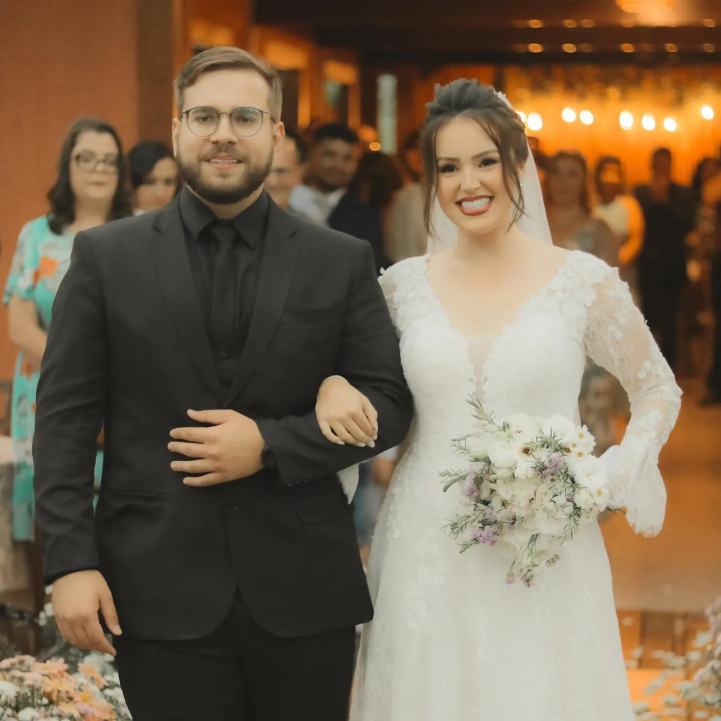 Noivos recém-casados sorrindo na saída da cerimônia