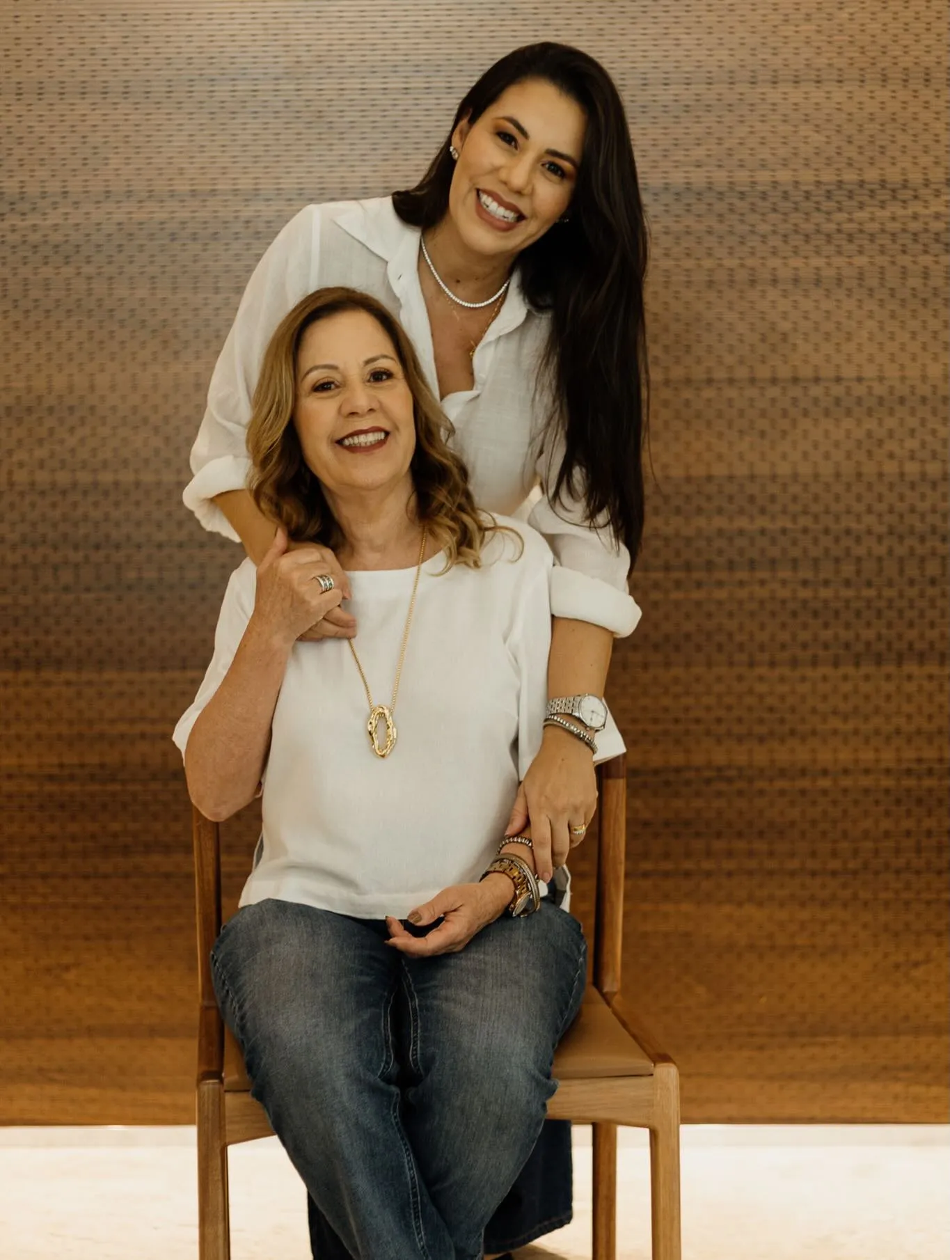 Mãe e filha adulta abraçadas, sorrindo, em ensaio de família